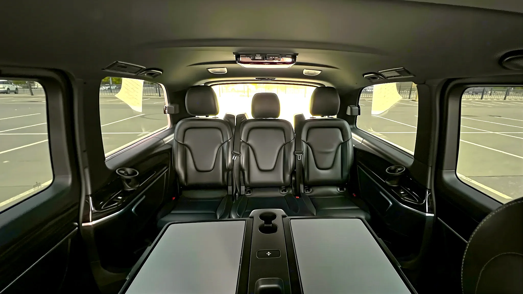 Чёрная Hyundai Staria LUX на 6 мест с фирменной передней оптикой припаркована у современных высотных домов