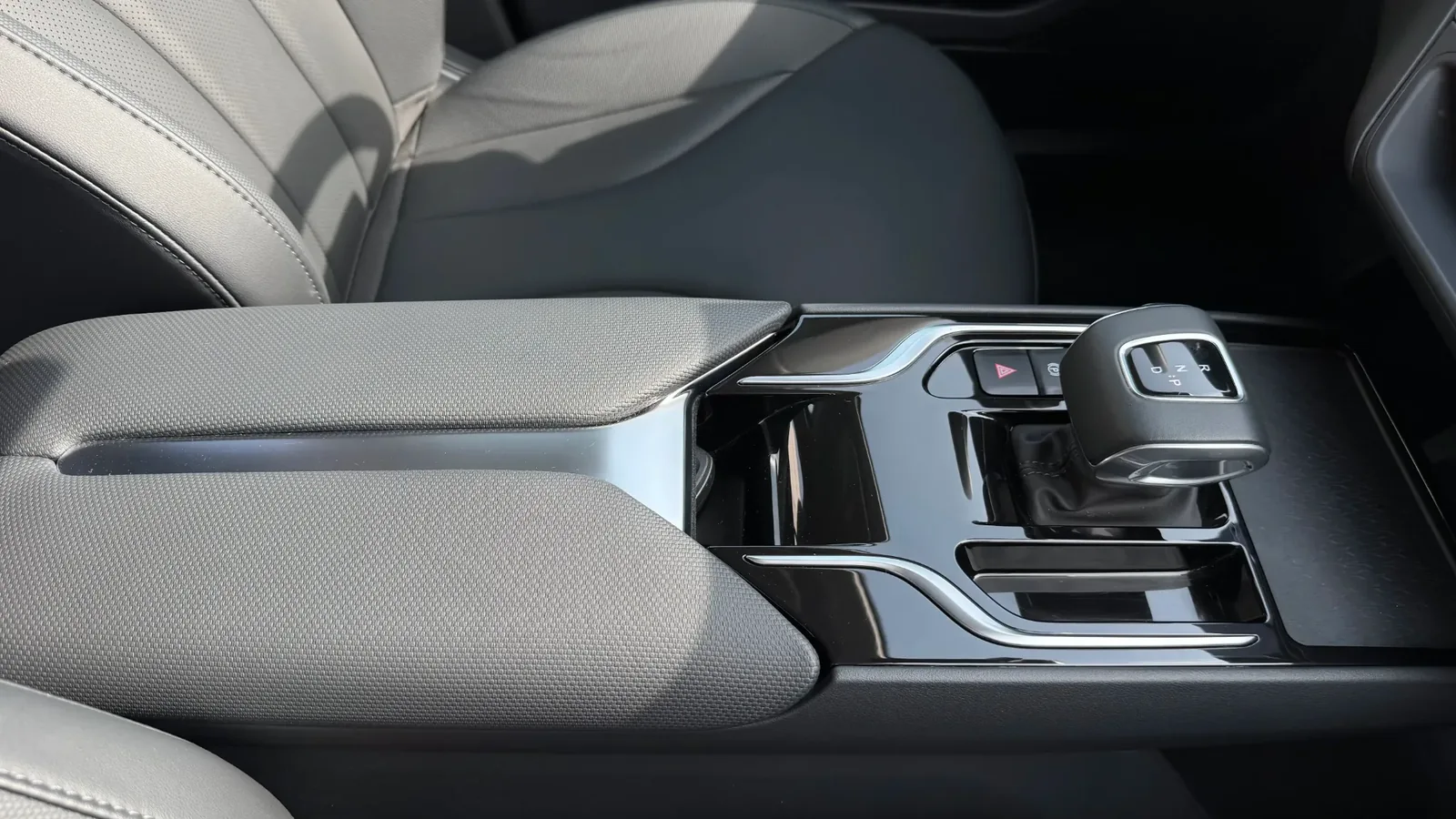 Подлокотник и подстаканники между передними сиденьями Hongqi E-QM5, показывающие комфорт для водителя и переднего пассажира