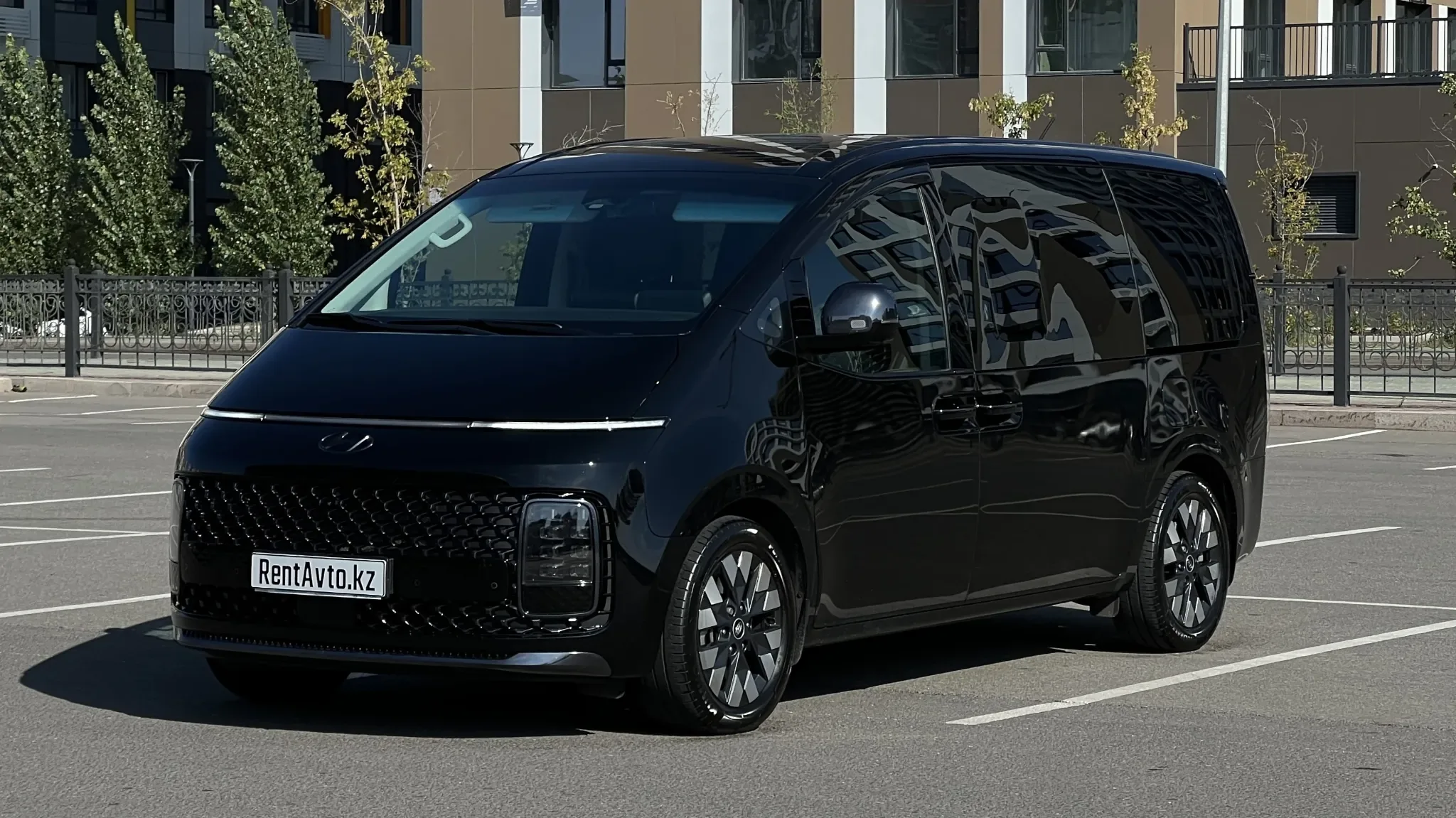 Чёрная Hyundai Staria LUX стоит у бизнес центра выполняя работу с иностранной делегацией