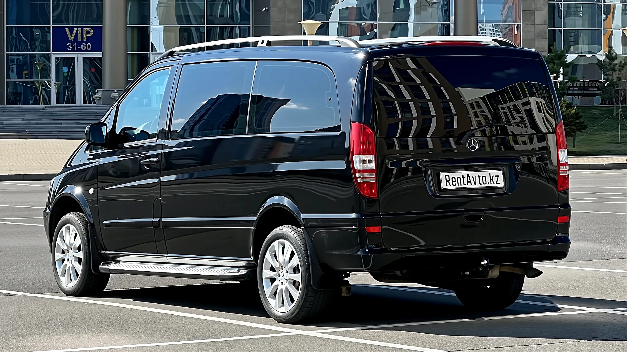 Mercedes-Benz Viano на 6 мест показан сзади на городской улице, видны крупные задние фонари и широкое стекло двери