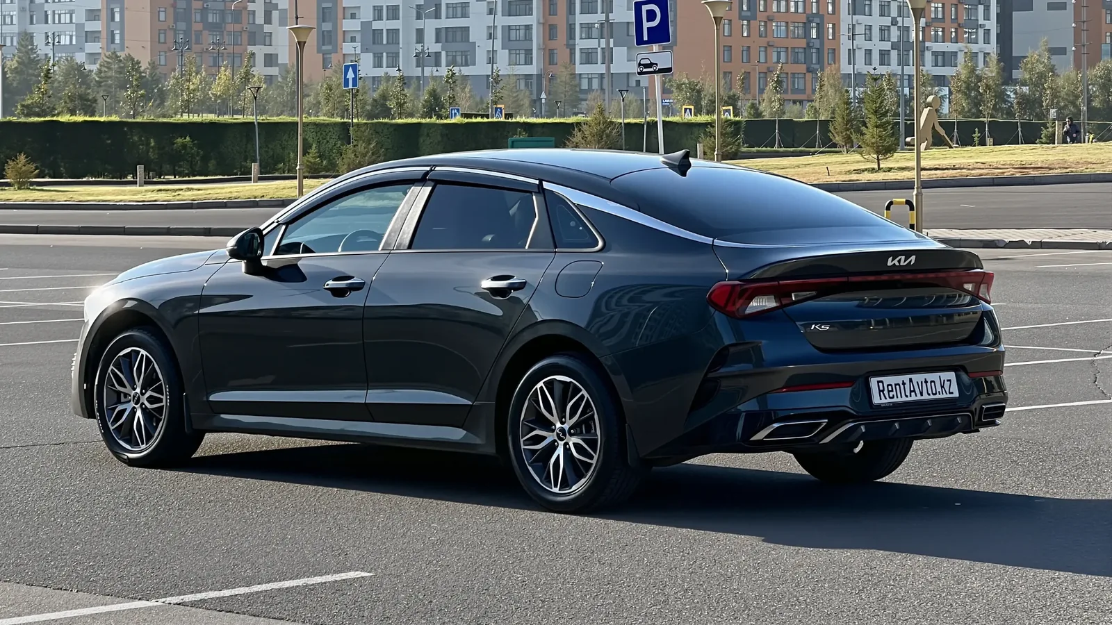 KIA K5 снята сзади на пустой парковке перед выездом в междугороднюю поездку с водителем из Астаны