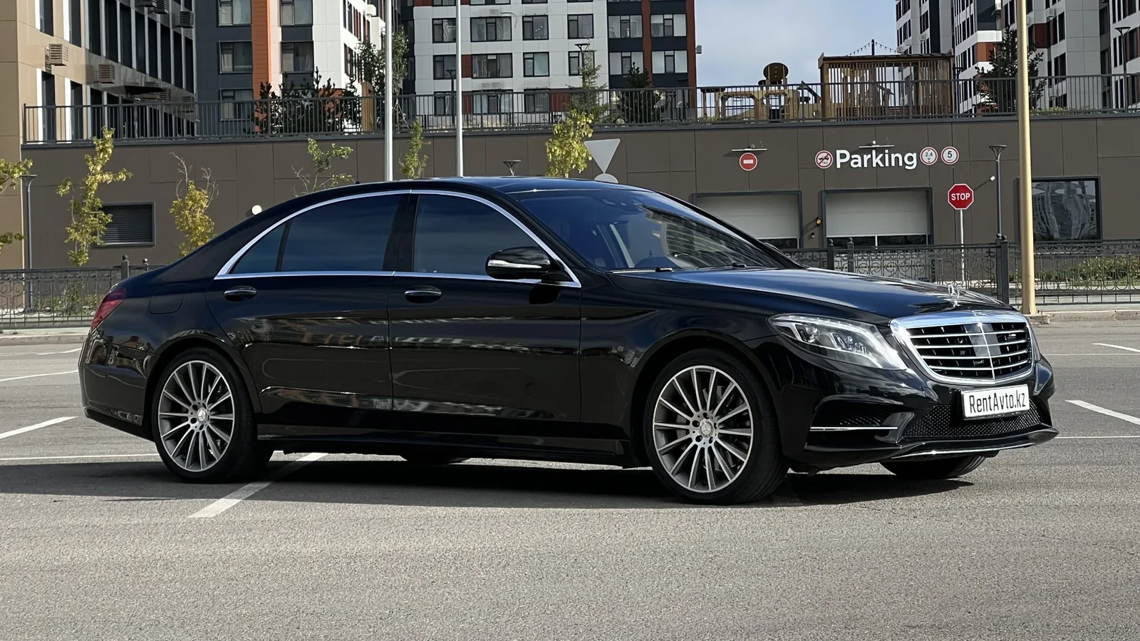 Чёрный Mercedes-Benz S-Class 222 движется по улице делового района Астаны, седан бизнес-класса берут в аренду с водителем по предварительному заказу