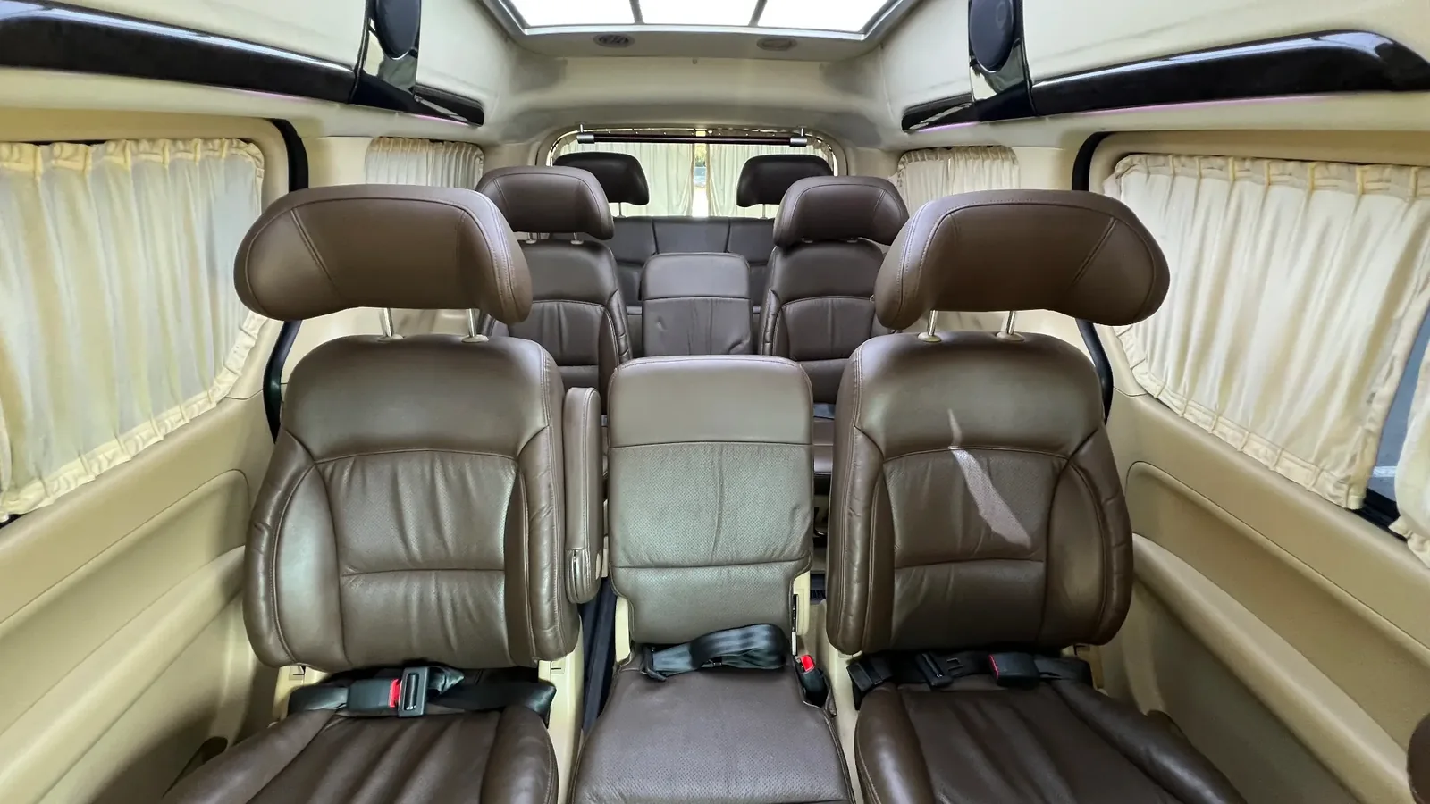 Бежевый салон Hyundai Grand Starex на 10 мест с высокими спинками кресел и светлой отделкой, удобный для поездок по Астане