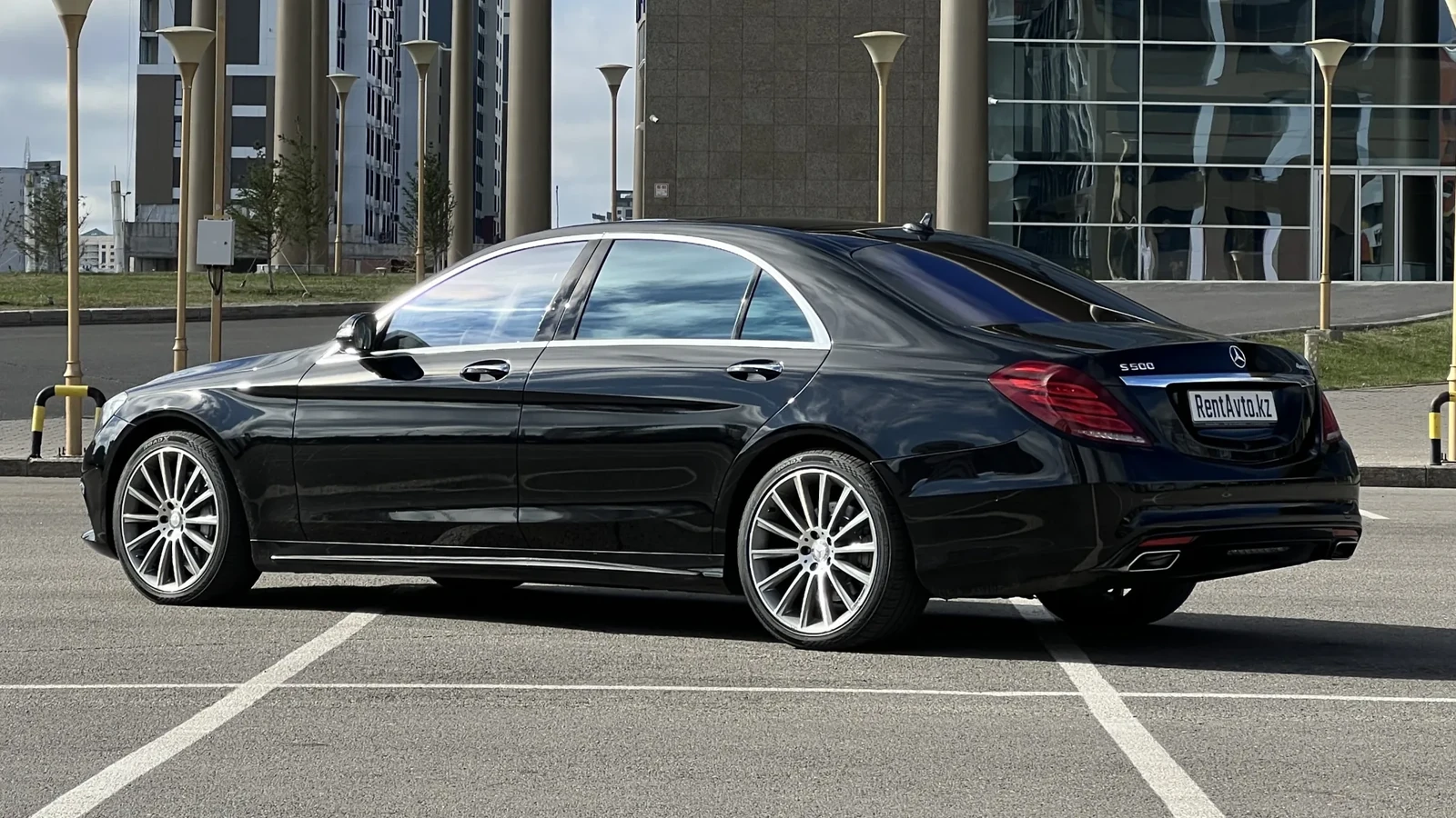 Mercedes-Benz S-Class 222 снят сзади на парковке у бизнес-центра, автомобиль служит комфортным вариантом трансфера с личным водителем между аэропортом и городом