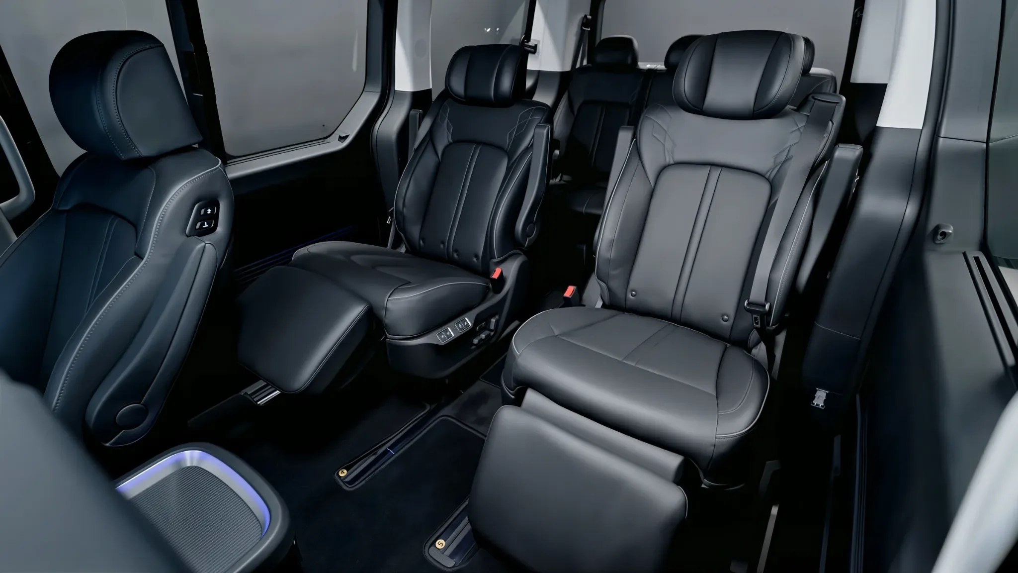 Два ряда кожаных кресел Hyundai Staria LUX с подголовниками и подлокотниками, между ними широкая центральная дорожка