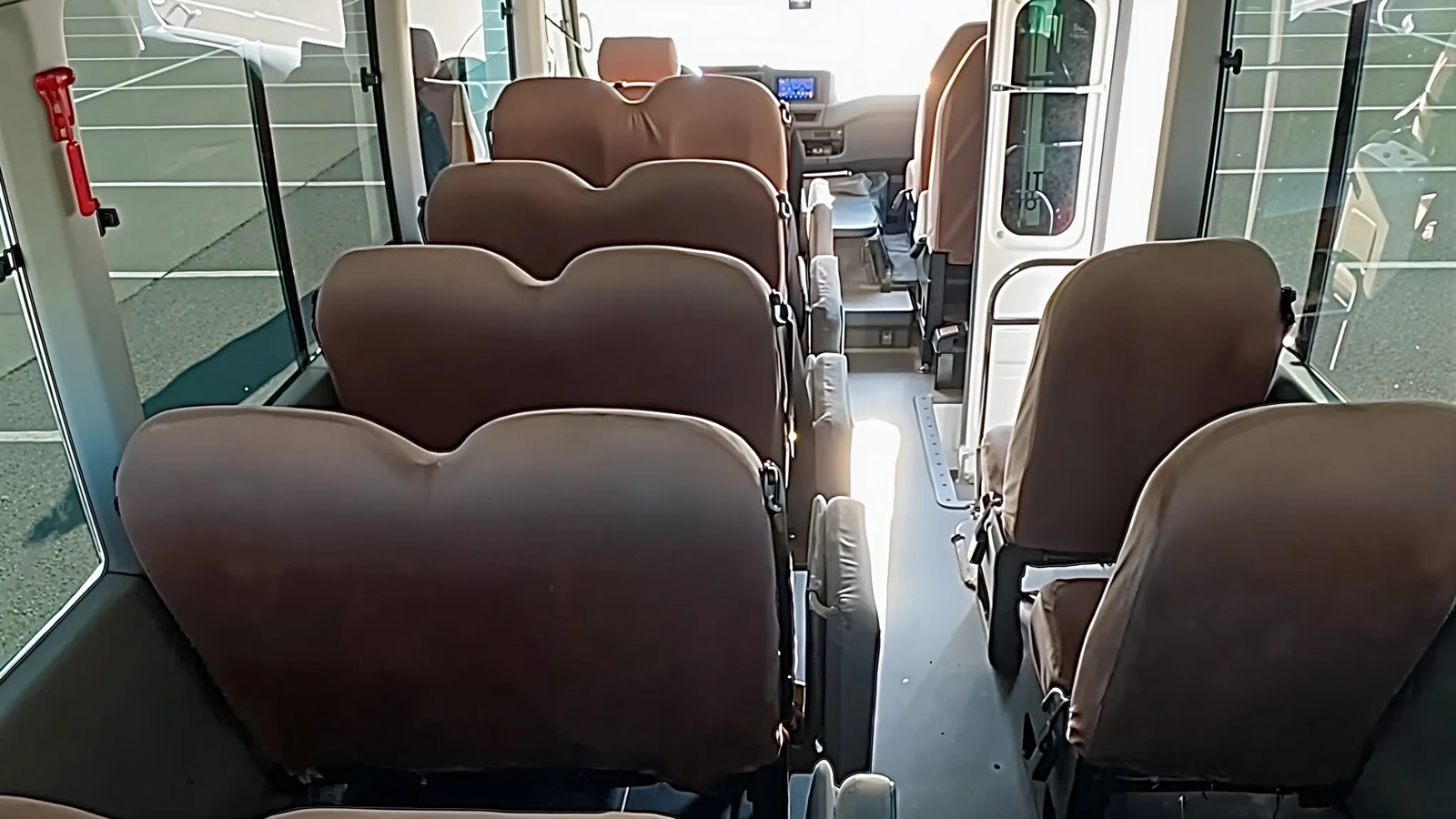 Белый автобус Toyota Coaster припаркован на площадке и подходит для корпоративных выездов небольшим коллективом