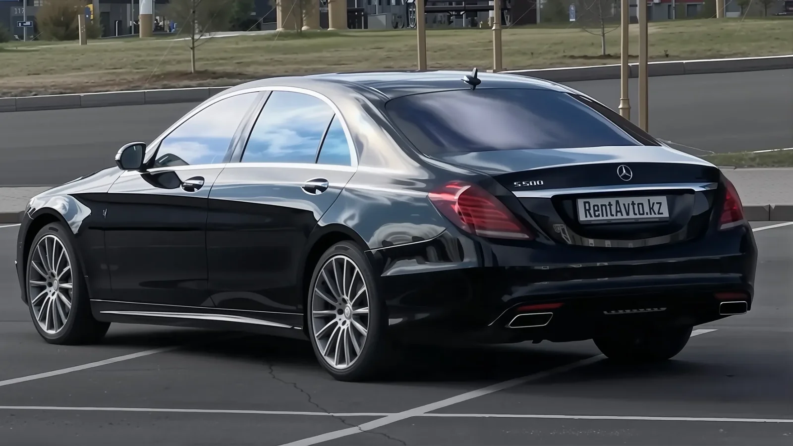 Чёрный Mercedes-Benz S-Class 222 на открытой парковке, задний ракурс седана бизнес-класса для аренды с водителем в Астане
