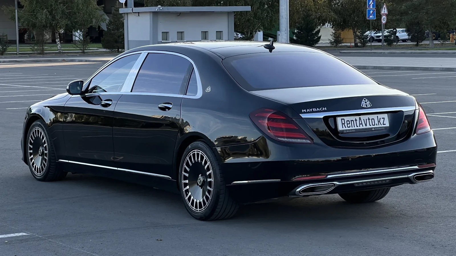 Чёрный Mercedes-Benz Maybach S-Class 222 снят сбоку на открытой площадке, седан предпочитают для межгородних поездок из Астаны по Казахстану с опытным водителем
