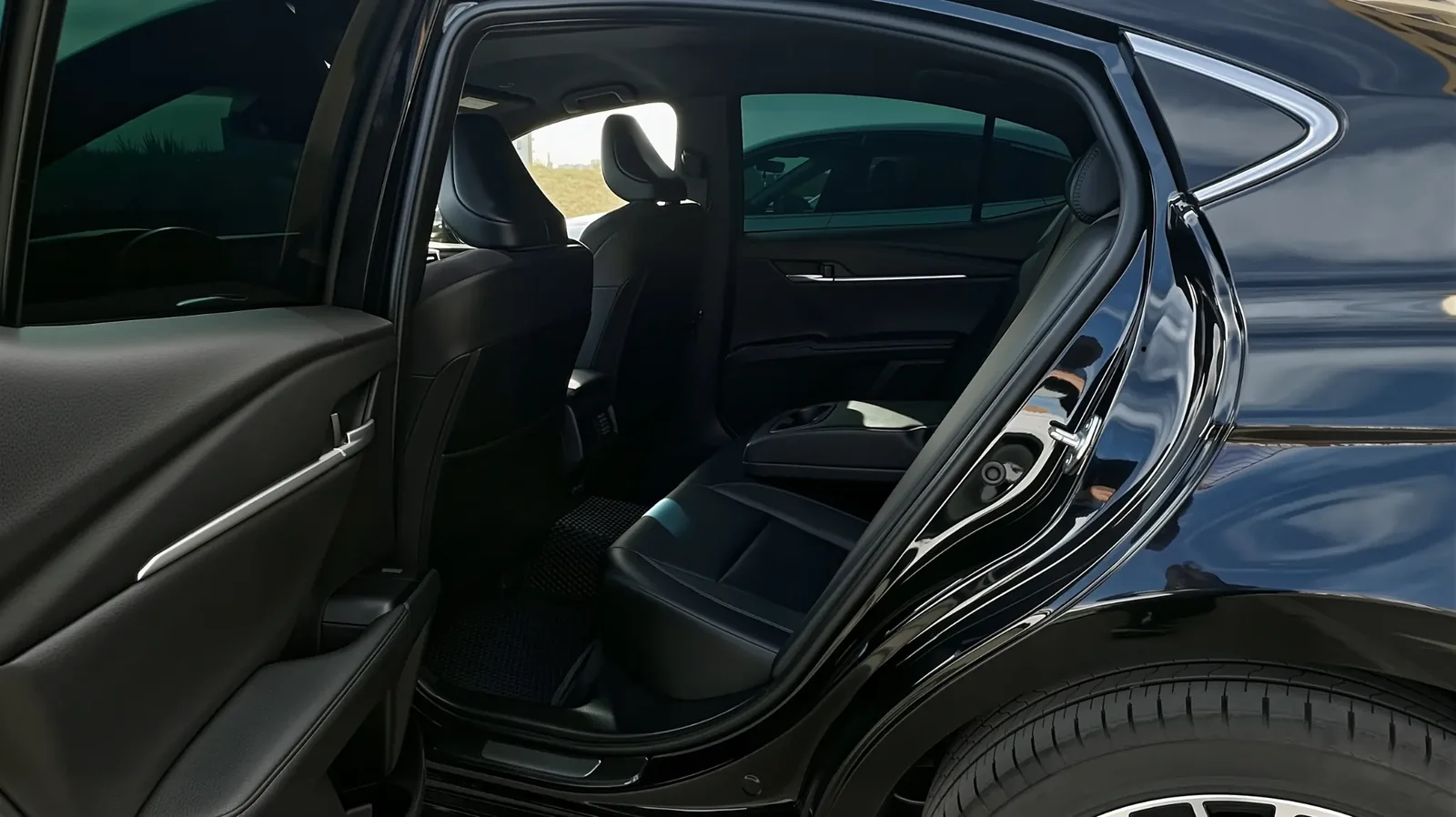 Открытая задняя дверь Toyota Camry 80 и вид на кожаные сиденья, седан подходит для формата работы с водителем на несколько дней