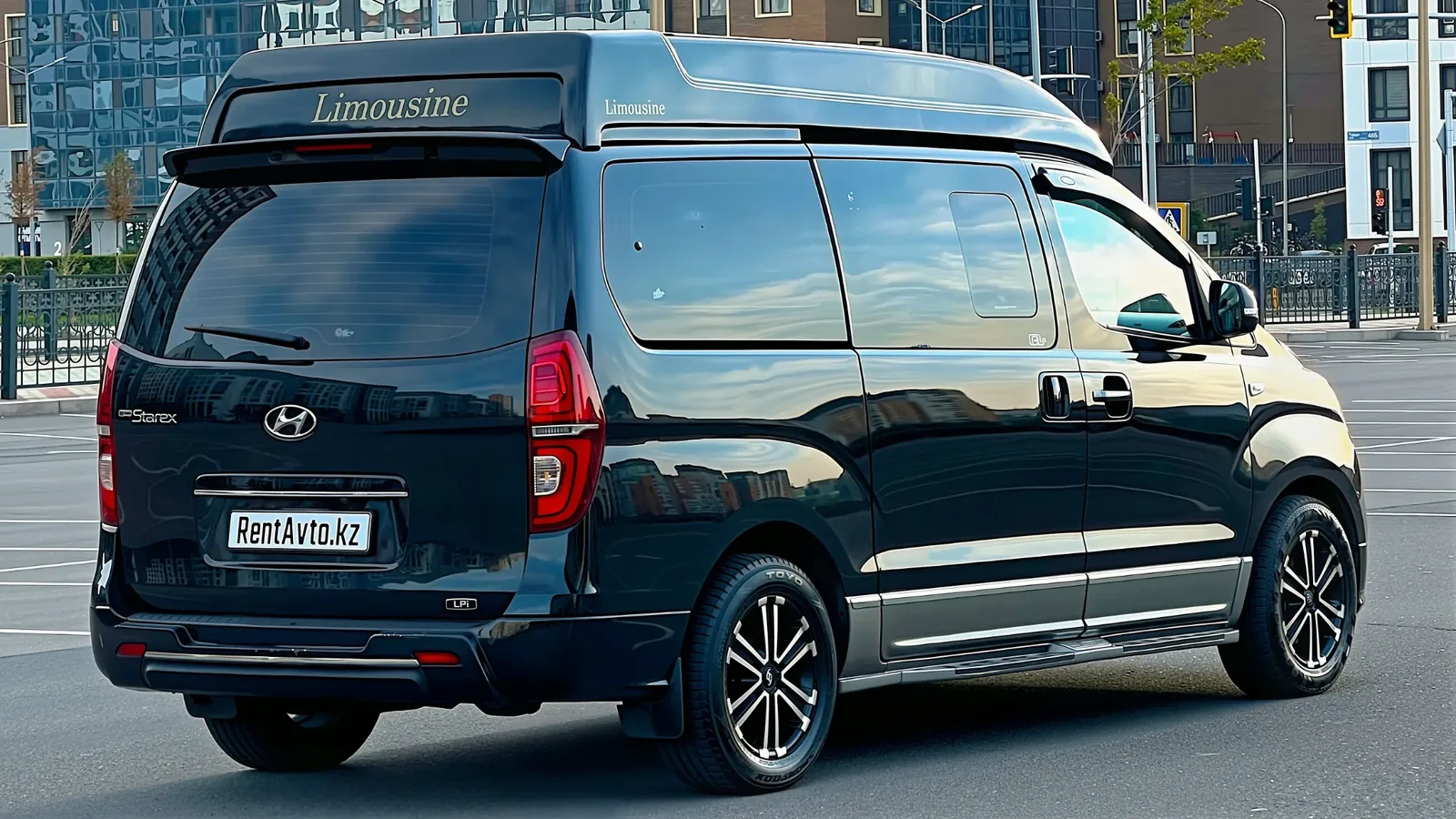 Grand Starex H1 сфотографирован сзади на парковке, видна высокая крыша и широкие задние двери, подходящие для корпоративного автопарка