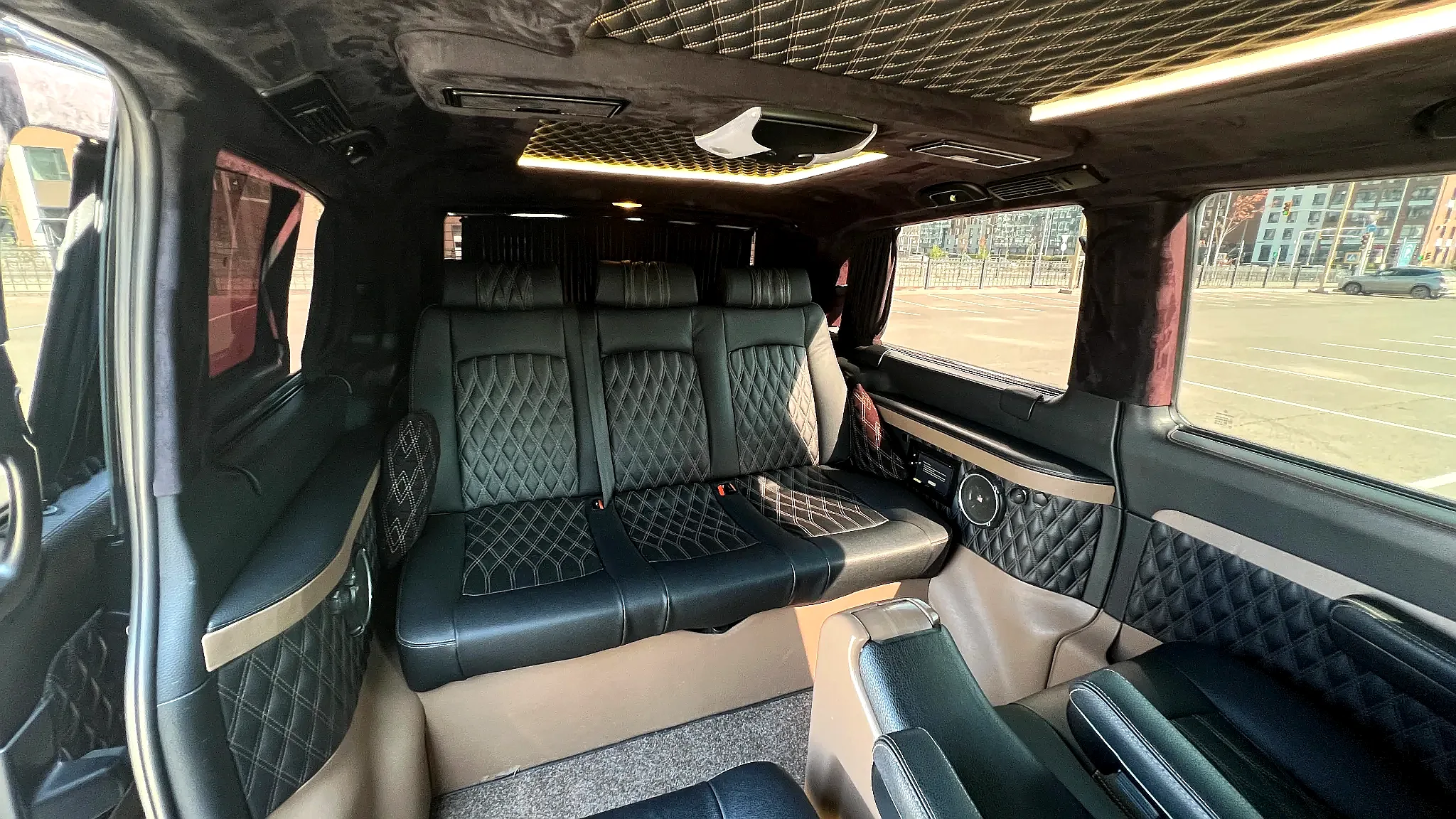 Продольный проход в салоне Mercedes-Benz Viano с декоративной подсветкой и тёмной отделкой, подчёркивающей современный стиль минивэна