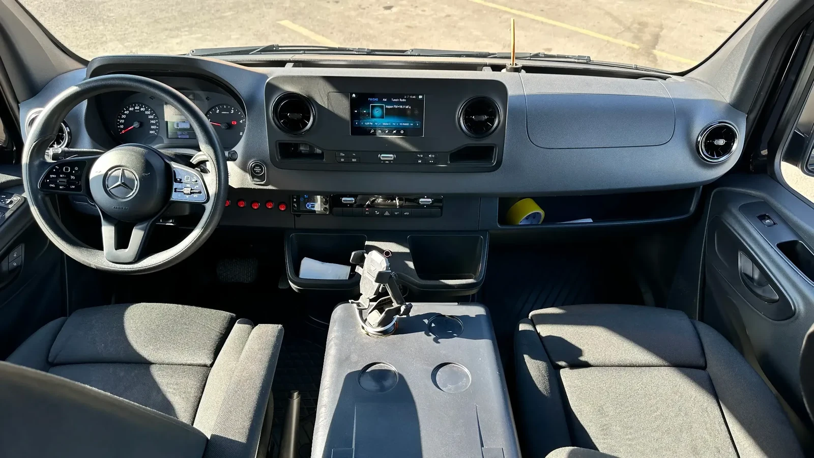 Задний ракурс чёрного Sprinter на 16 мест на стоянке автопарка в Астане