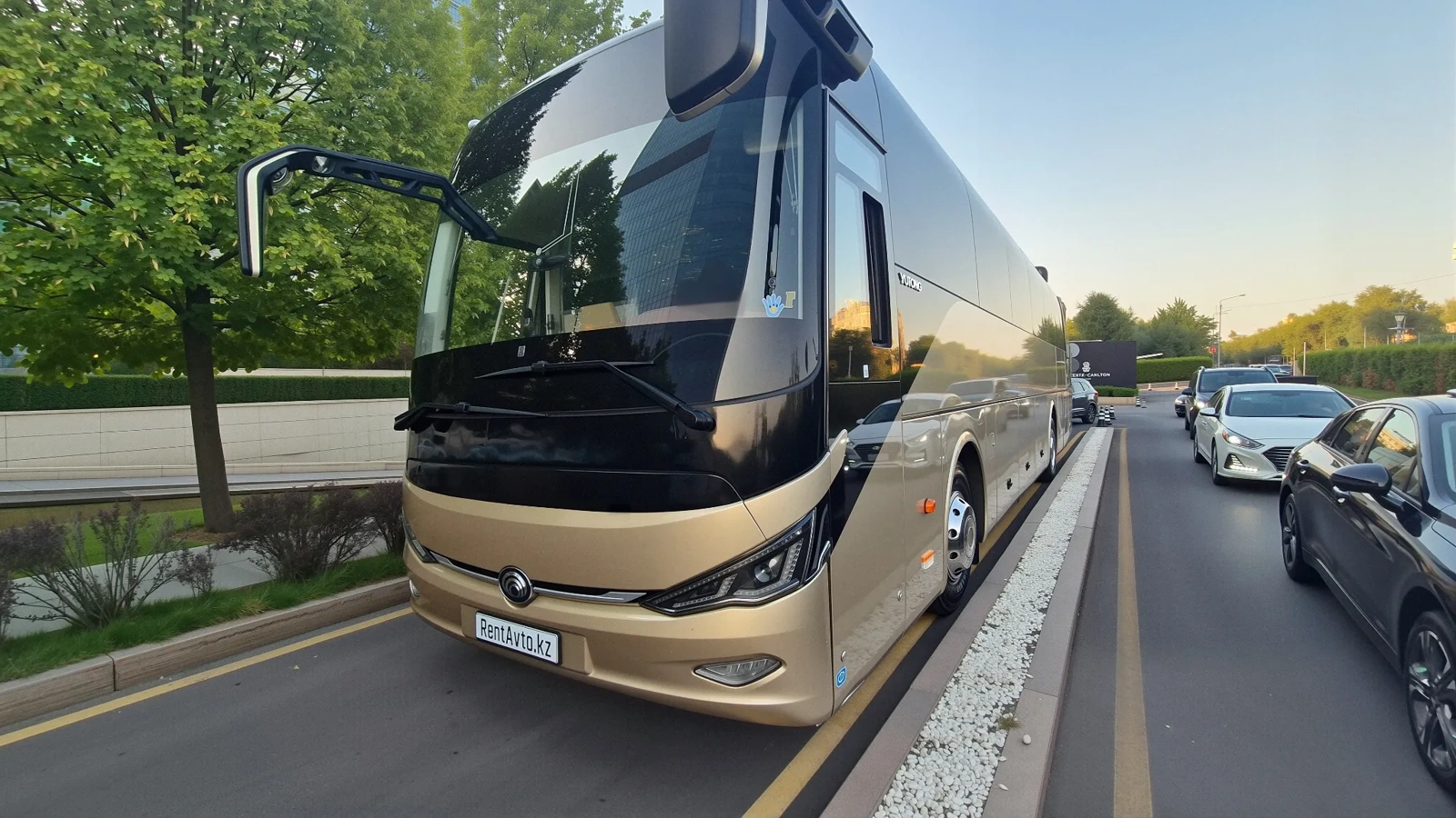 Автобус Yutong на 52 места движется по городу, обслуживая организованные групповые поездки с профессиональным водителем