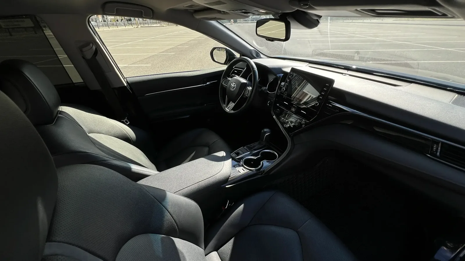 Вид на переднюю панель и руль Toyota Camry 75, седан предварительно заказывают с водителем для встреч гостей и партнёров