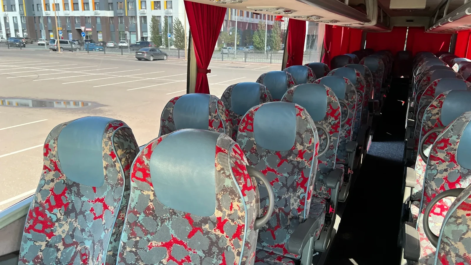 Салон автобуса VanHool на 50 мест с яркими чехлами кресел, используемого для групповых поездок