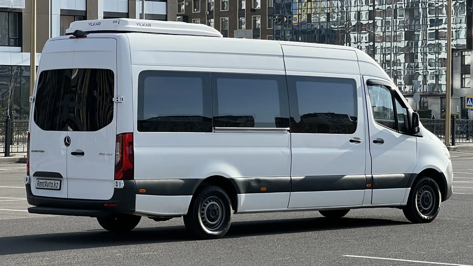 Белый микроавтобус Мерседес Спринтер на 17 мест в боковом ракурсе на парковке Астаны