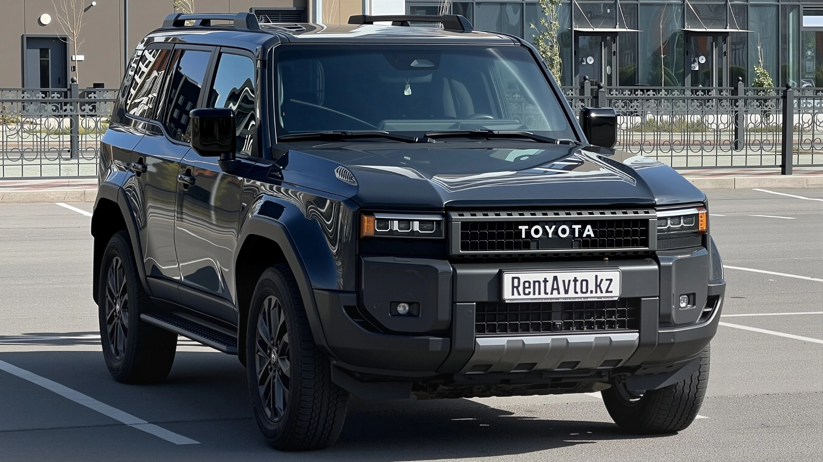 Передний ракурс Toyota Land Cruiser Prado 250 на парковке в Астане, используемый при аренде автомобиля, а поездки с водителем нередко оформляют по заказу
