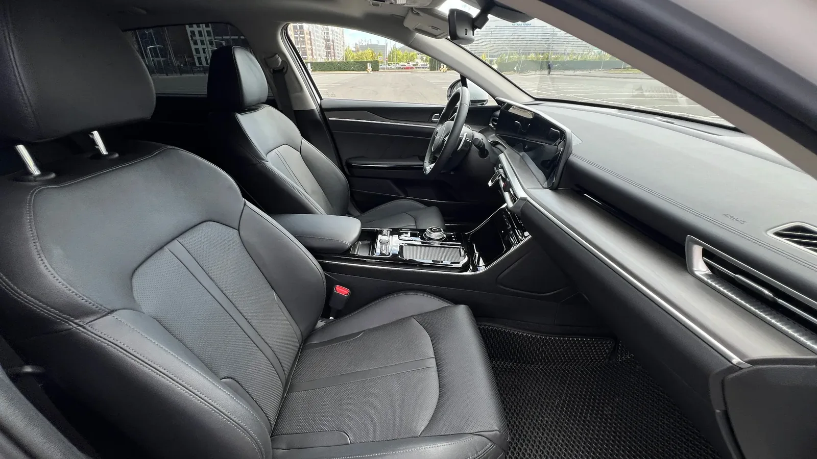 Центральная консоль KIA K5 с мультимедийным экраном и органами управления, подчёркивающая уровень сервиса автомобиля с водителем