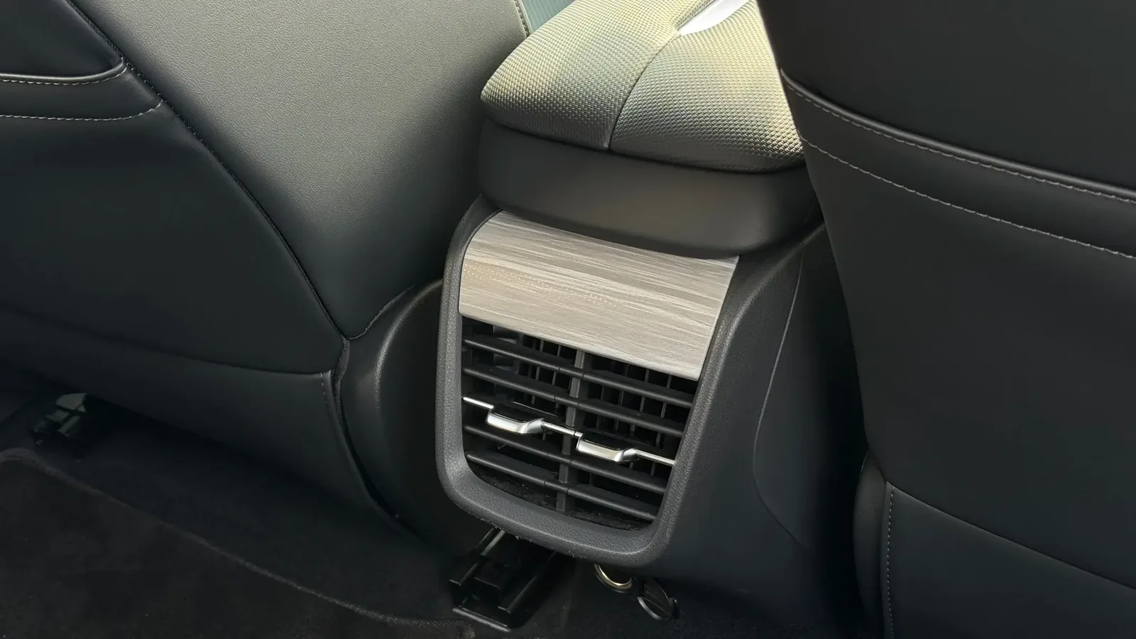 Центральная консоль для задних пассажиров Hongqi E-QM5 с воздуховодами и декоративной вставкой, подчёркивающая оснащение салона