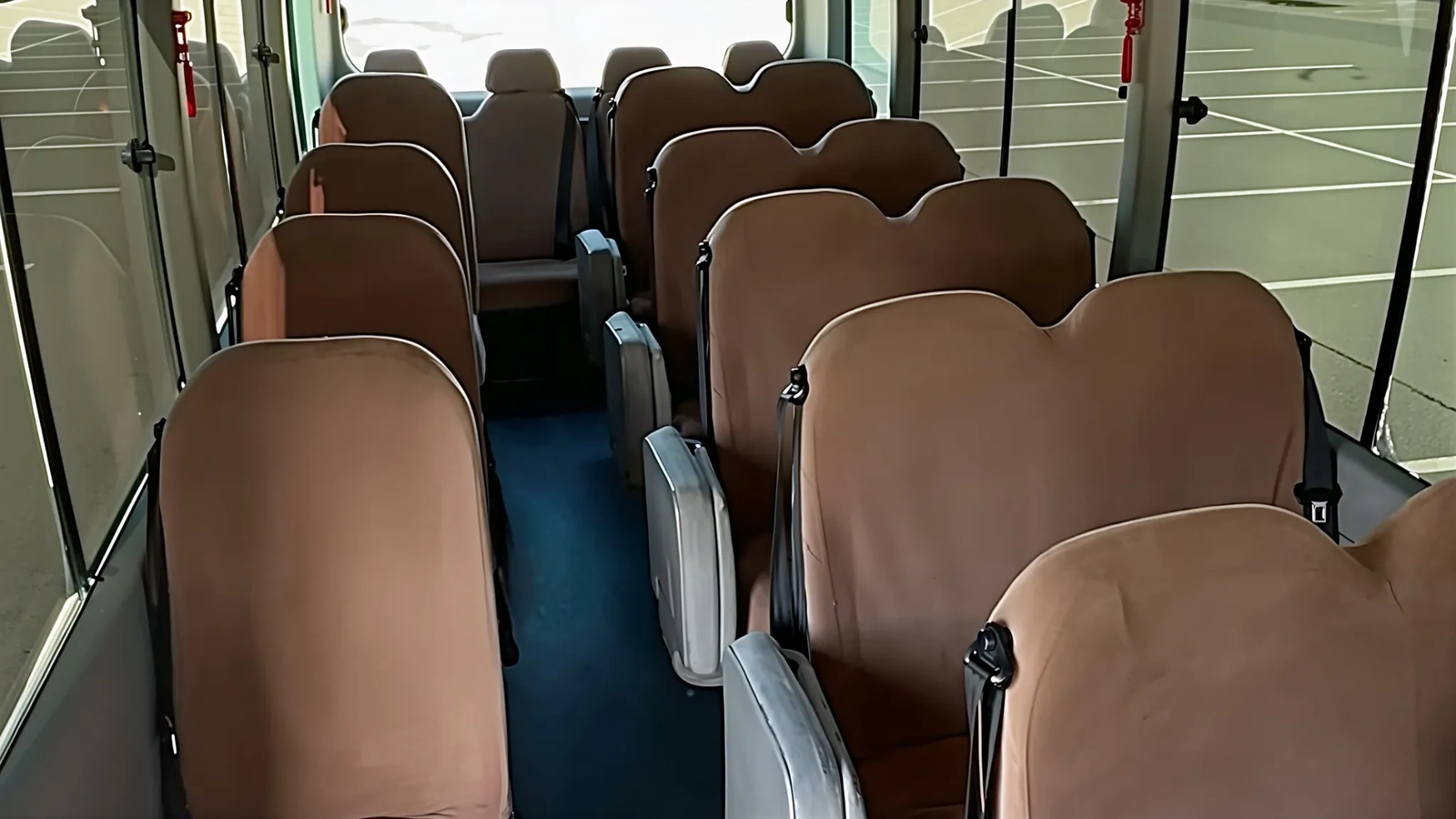 Автобус Toyota Coaster стоит на асфальтовой площадке, его часто выбирают для кортких передвижений с водителем