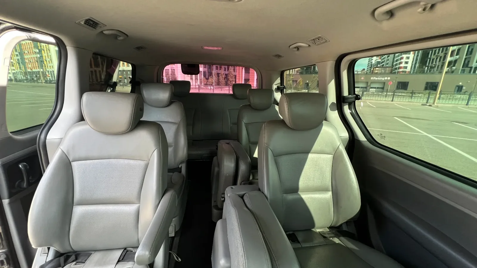 Внутреннее пространство Grand Starex с несколькими рядами кресел и крупными боковыми окнами