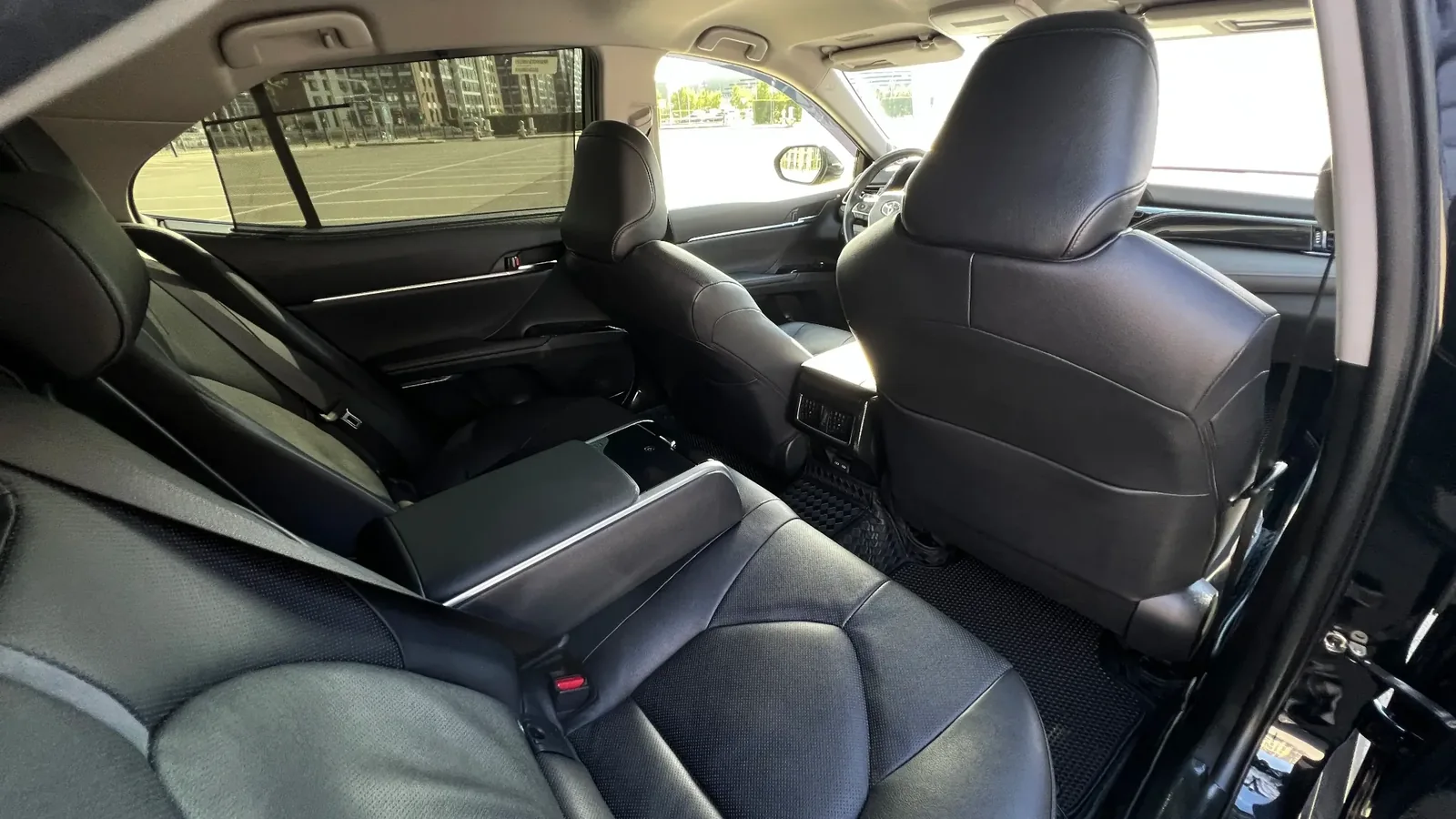 Задний ряд Toyota Camry 75 с откинутым подлокотником на трёх пассажиров, удобный для бесперебойной работы автомобиля с водителем