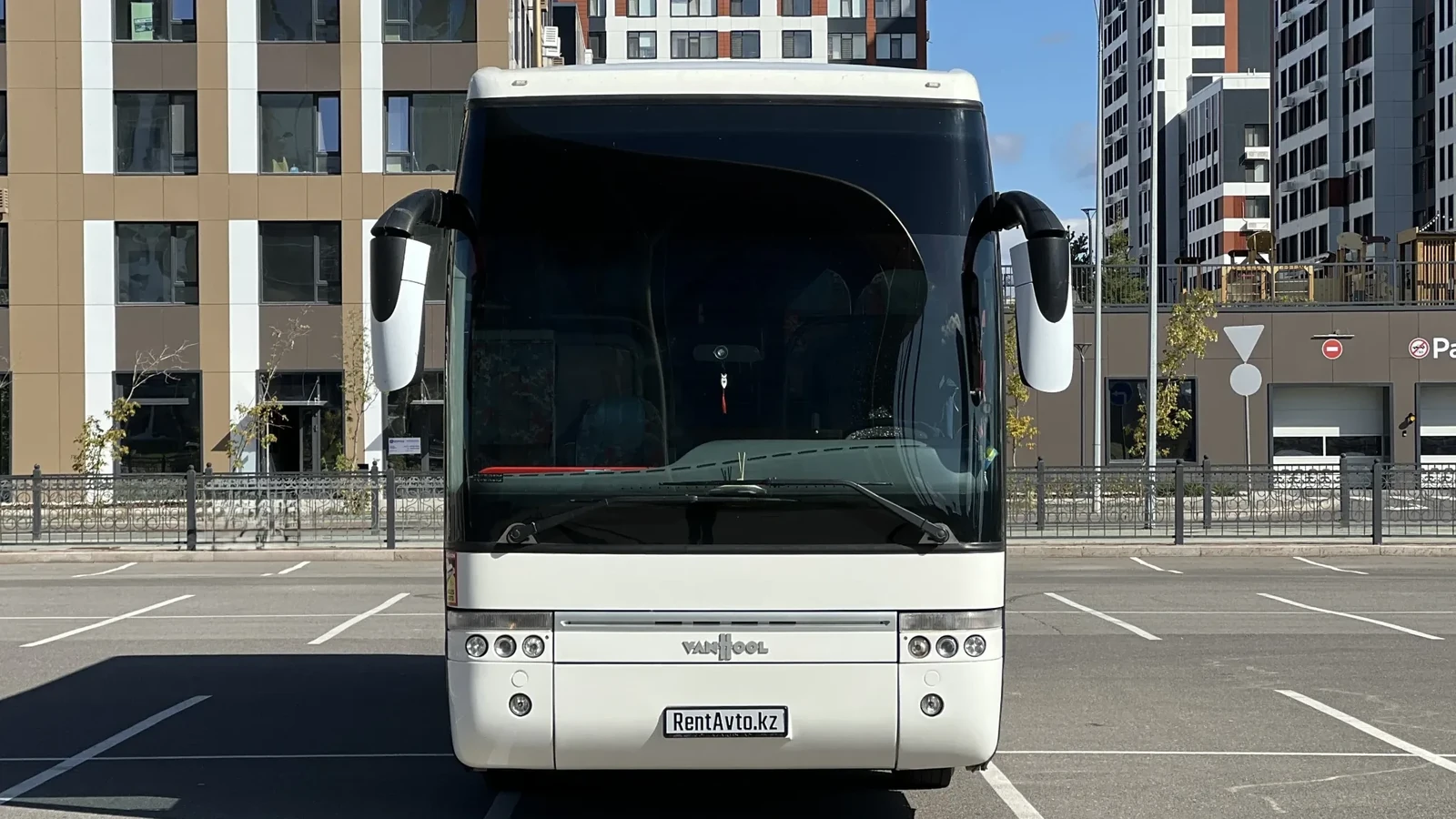 Белый автобус VanHool на 50 мест стоит на асфальтовой площадке, его берут в прокат для больших групп